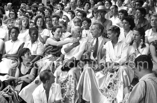 Jacqueline getting a suck of Pablo Picasso’s ice cream cornet, in the background Paloma Picasso, Maya Picasso, Claude Picasso, on the right Jean Cocteau and Francine Weisweiller and her daughter Carole, on the left Henri Lartigue's wife Florette. At a bullfight put on in Pablo Picasso's honor at Vallauris 1955. - Photo by Edward Quinn