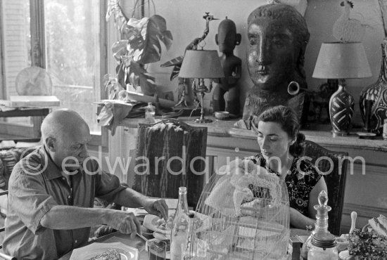 Pablo Picasso and Jacqueline. Luncheon at the dining and work table. Jacqueline is wearing a dress with printed motifs of a Pablo Picasso work. La Californie, Cannes 1956. - Photo by Edward Quinn