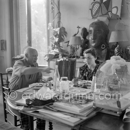 Pablo Picasso and Jacqueline. Luncheon at the dining and work table. Jacqueline is wearing a dress with printed motifs of a Pablo Picasso work. La Californie, Cannes 1956. - Photo by Edward Quinn