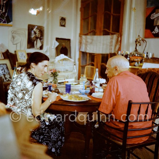 Pablo Picasso and Jacqueline. Luncheon at the dining and work table. Jacqueline is wearing a dress with printed motifs of a Pablo Picasso work. La Californie, Cannes 1956. - Photo by Edward Quinn