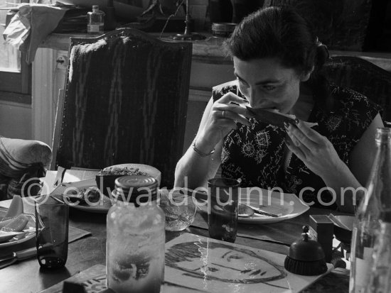 Jacqueline. Luncheon at the dining and work table. She is wearing a dress with printed motifs of a Pablo Picasso work. La Californie, Cannes 1956. - Photo by Edward Quinn