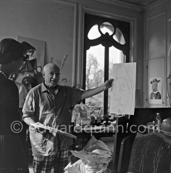 Pablo Picasso shows a drawing he has done of his friend the writer Jacques Prévert. On the left Susi Magnelli. La Californie, Cannes 24.10.1956. (Eve of Pablo Picasso\'s 75th birthday.) - Photo by Edward Quinn