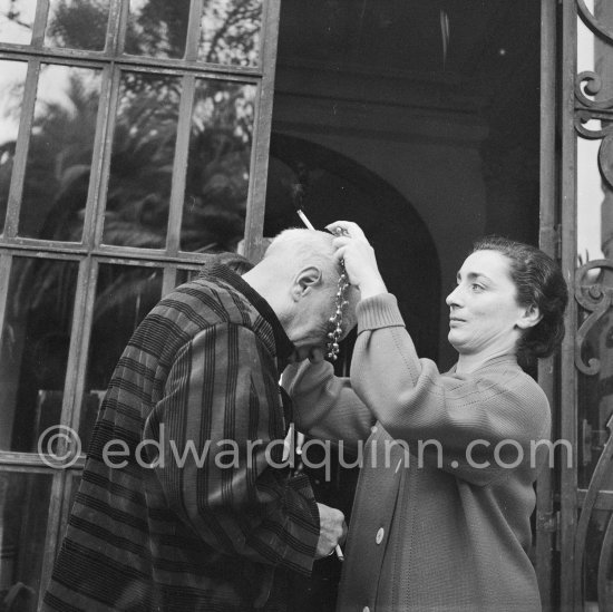 To enhance the effect of a new veluet blouse given him for his birthday, Pablo Picasso wears one of Jacqueline's necklaces and mimes what he imagines to be the appropriate expression for an ancient emperr. On the occasion of his 75th birthday on 25.10. La Californie, Cannes 1956. - Photo by Edward Quinn