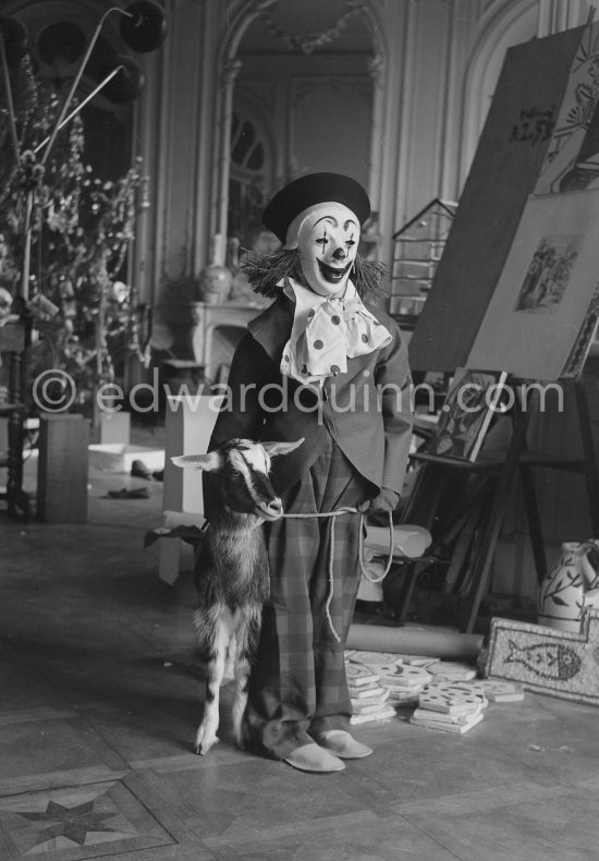 Pablo Picasso with Claude Picasso dressed up as a clown. With goat Esmeralda. La Californie, Cannes 1956. - Photo by Edward Quinn