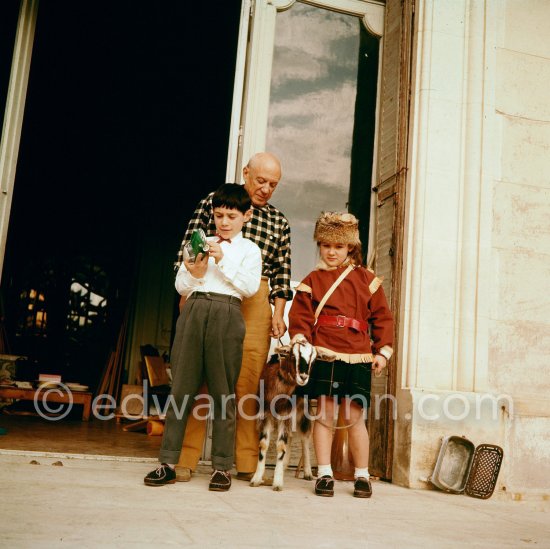 Pablo Picasso, Claude Picasso and Paloma Picasso at Christmas with Esmeralda. Claude Picasso with his Christmas present, a toy Citroën DS. Paloma Picasso is wearing the Davy Crockett outfit she received as a Christmas present. La Californie, Cannes 1956. - Photo by Edward Quinn