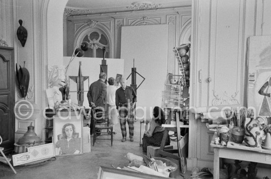 Pablo Picasso showing Suzanne and George Ramié wood sculptures "The Bathers (Les Baigneuses)". On the right Jacqueline. La Californie, Cannes 1957. - Photo by Edward Quinn