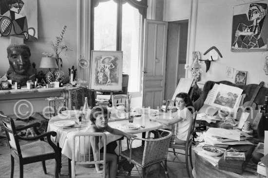 Paloma Picasso and Catherine Hutin. Large sofa weighed down with an array of papers, prints, guitar. La Californie, Cannes 1957. - Photo by Edward Quinn