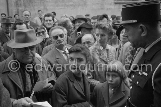 Aika Sapone, daughter of Michele Sapone, Pablo Picasso\'s tailor, waiting for unveiling of mural "The Fall of Icarus" for the conference hall of UNESCO building in Paris. The mural is made up of forty wooden panels. Initially titled "The Forces of Life and the Spirit Triumphing over Evil", the composition was renamed in 1958 by George Salles, who preferred the current title, "The Fall of Icarus". Vallauris, 29 March 1958. - Photo by Edward Quinn