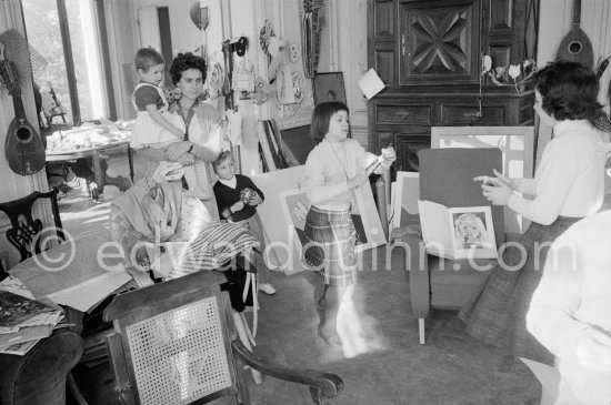Paloma Picasso pulls a surprise cracker with Catherine Hutin. The Dominguin children and Inès Sassier, Pablo Picasso's housekeeper look on. The book open on the armchair shows a portrait of Paloma Picasso. Pablo Picasso, La Californie, Cannes 1959. - Photo by Edward Quinn