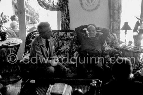 Jean Cocteau and Pablo Pablo Picasso. Outside Pablo Picasso\'s tailor Michele Sapone and Jaime Sabartés. During filming of "Le Testament d’Orphée", film of Jean Cocteau. Saint-Jean-Cap-Ferrat 1959. - Photo by Edward Quinn