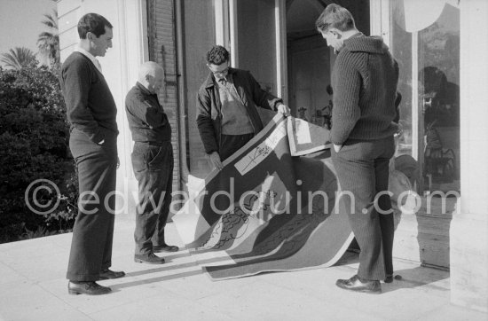 Pablo Picasso discussing with the expert Pierre Baudouin the project for a tapestry designed by him. Luis Miguel Dominguin and at right Paulo Picasso. La Californie, Cannes 1959. - Photo by Edward Quinn