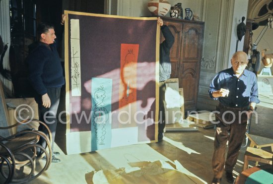 Pablo Picasso and Paulo Picasso with tapestry "Les clowns à la lune bleue". La Californie, Cannes 1959. - Photo by Edward Quinn