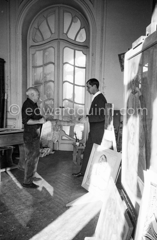 Pablo Picasso with a Spanish wicker mask of a bull, originally intended for bullfighters\' training, takes a lesson in bull fighting from an expert, the matador Luis Miguel Dominguin. La Californie, Cannes 1959. - Photo by Edward Quinn