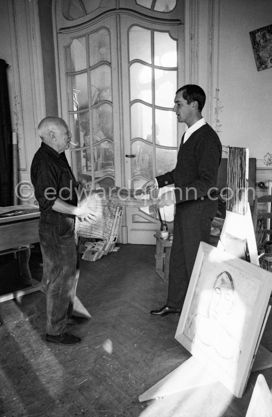 Pablo Picasso with a Spanish wicker mask of a bull, originally intended for bullfighters\' training, takes a lesson in bull fighting from an expert, the matador Luis Miguel Dominguin. La Californie, Cannes 1959. - Photo by Edward Quinn