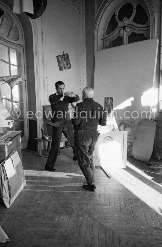 Pablo Picasso with a Spanish wicker mask of a bull, originally intended for bullfighters\' training, takes a lesson in bull fighting from an expert, the matador Luis Miguel Dominguin. La Californie, Cannes 1959. - Photo by Edward Quinn