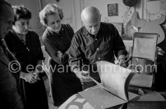 Pablo Picasso shows a sketchbook (drawing 17.7.1959.) Gathered around him as he comments on the book are Lucie Weill, a Paris publisher, the writer Michel Leiris, his wife Louise Leiris, owner with Daniel-Henry Kahnweiler of the Leiris Gallery Paris. La Californie, Cannes 1959. - Photo by Edward Quinn