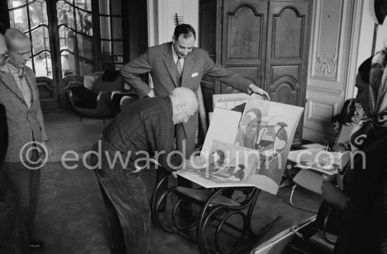 Pablo Picasso signing. The writer Michel Leiris and André Weill, publisher of some deluxe editions of Pablo Picasso\'s work, and Jacqueline. La Californie, Cannes 1959. - Photo by Edward Quinn