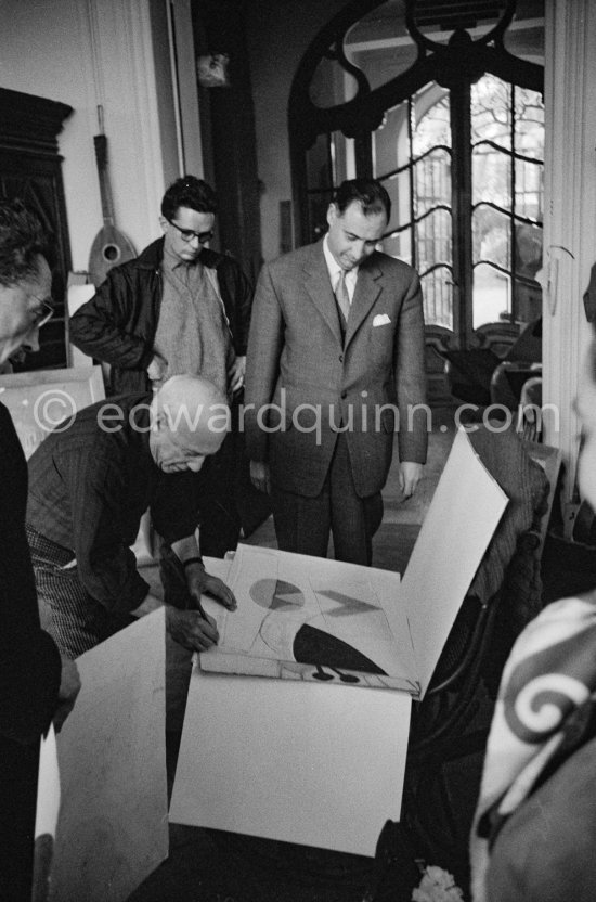 Pablo Picasso signing. André Weill, publisher of some deluxe editions of Pablo Picasso's work and Pierre Baudouin. La Californie, Cannes 1959. - Photo by Edward Quinn