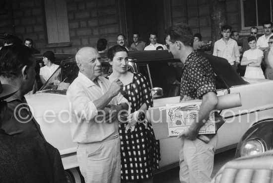 Pablo Picasso, Jacqueline and photographer Lucien Clergue with his book "Poesie der Photographie (Cologne, 1960)". After the bullfight, Arles 1960. - Photo by Edward Quinn