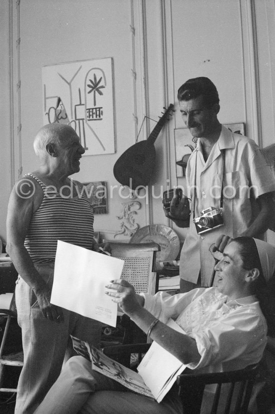 Pablo Picasso, Jacqueline and Edward Quinn discuss a choice of photographs for the book "Pablo Picasso at work". Quinn with his Leica M3 and Rolleiflex 3.5B. La Californie, Cannes 8.9.1960. Photographer unknown. - Photo by Edward Quinn