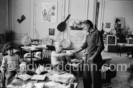 Pablo Picasso, photographer David Douglas Duncan and Claude Picasso. On the table a pile of english newspapers reporting on Pablo Picasso\'s London exhibition. La Californie, Cannes 1960. - Photo by Edward Quinn