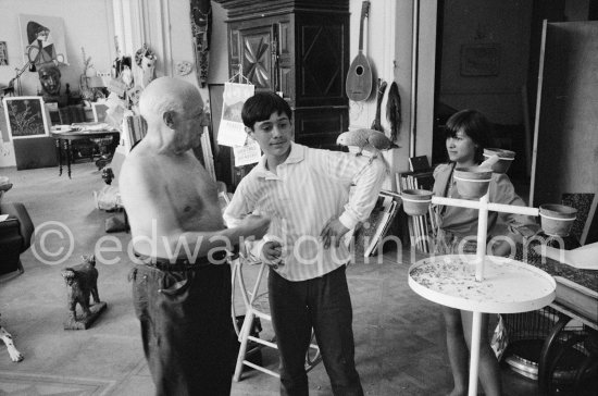 Pablo Picasso introduces Claude Picasso to a new pet, a talking parrot, which is squatting on his arm. La Californie, Cannes 1960. - Photo by Edward Quinn