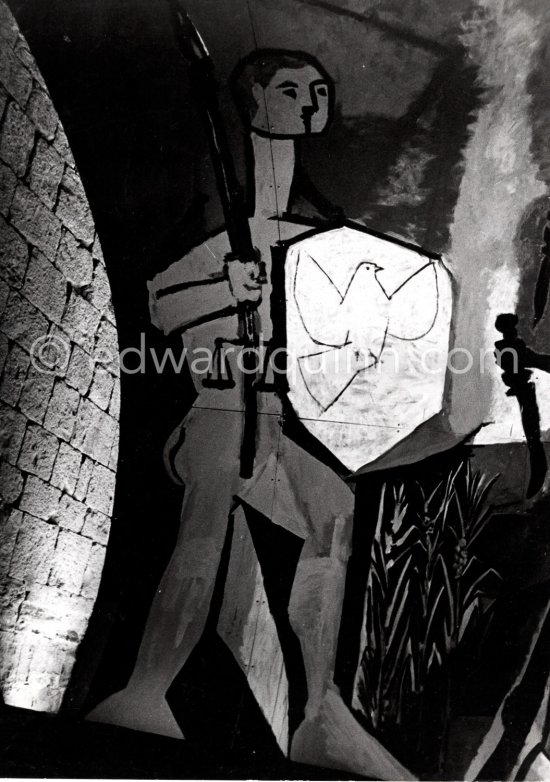 War and Peace ("La Guerre et la Paix") drawing on the vault of the Temple of Peace (Temple de la Paix, or Chapelle de la paix). Pablo Picasso had added a semicircular panel with four interlocked figures holding a dove of peace, suggesting the unity of mankind. Vallauris 1961. (Digitized from Vintage Print, original negative missing) - Photo by Edward Quinn