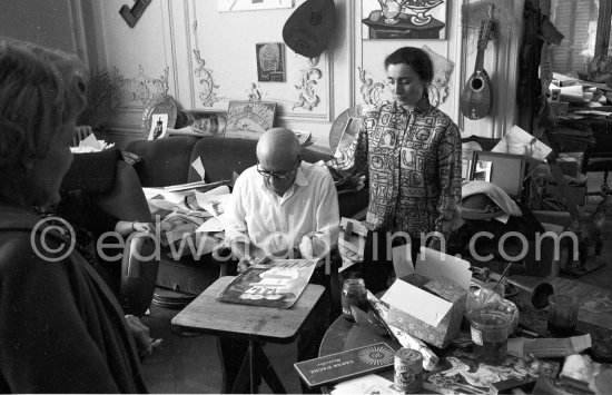 Pablo Picasso working on gouache with Caran d'Ache wax oil pastels and water color. Pablo Picasso always liked surprises and in his work he encouraged unpredictable outcomes. Jacqueline is wearing a blouse made from a textile designed by Pablo Picasso. Oj the left Suzanne rRmié. La Californie, Cannes 1961. - Photo by Edward Quinn