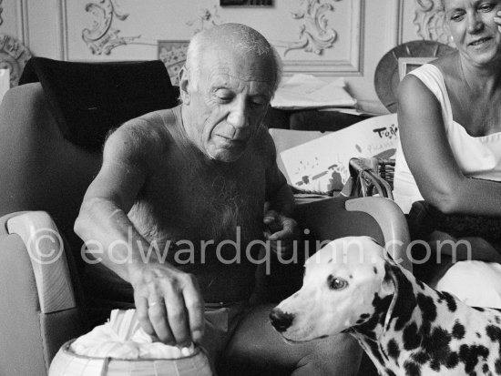 A piece of sugar for Perro. On the right beside Pablo Picasso the wife of Spanish painter Antoni Clavé. La Californie, Cannes 1961. - Photo by Edward Quinn