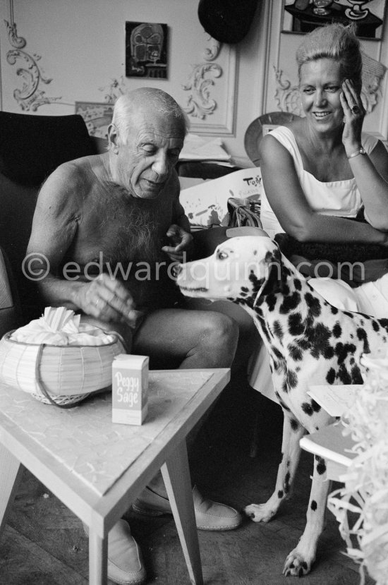 A piece of sugar for Perro. On the right beside Pablo Picasso the wife of Spanish painter Antoni Clavé. La Californie, Cannes 1961. - Photo by Edward Quinn
