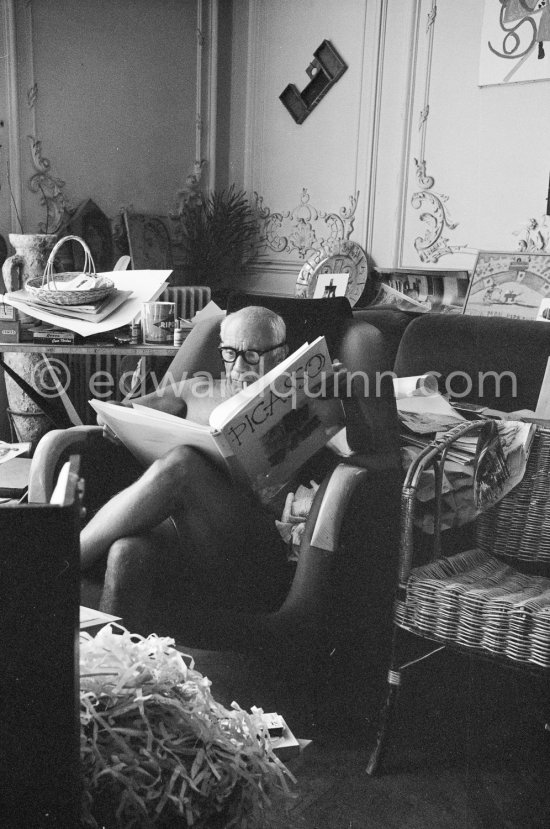 Pablo Picasso viewing a book on himself. Ripolin can in the background. With a Ripolin can. La Californie, Cannes 1961. - Photo by Edward Quinn