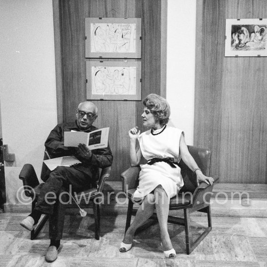 Pablo Picasso (with Soshana Afroyim exhibition brochure) and Suzanne Ramié. Exhibition "Les Déjeuners". Dessins originaux de Pablo Picasso, Galerie Madoura. Cannes 1962. - Photo by Edward Quinn