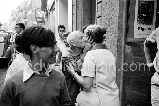 Pablo Picasso and Hélène Parmelin. His sons Paulo Picasso and Claude Picasso on the left. In front of Galerie Cavalero. Exhibition "Pignon. Gouaches, aquarelles". Cannes 1962. - Photo by Edward Quinn