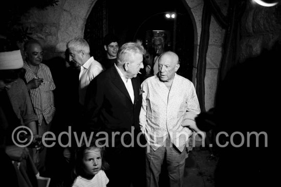 Pablo Picasso and Jacques Prévert. On the left in the background the photographer Brassaï in conversation with Pierre Prévert, the brother of Jacques. The girl is Yoyo Maeght, the grandchild of Aimé Maeght. Opening of the exhibition "Images de Jacques Prévert", Château Grimaldi, Antibes, 6.8.1963. - Photo by Edward Quinn