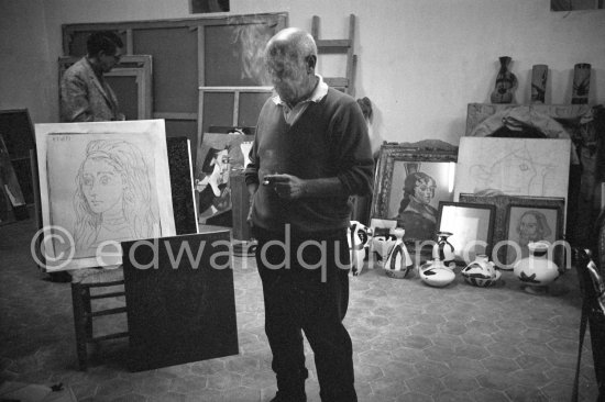In his studio at Mas Notre-Dame-de-Vie, Pablo Picasso shows for comparison his original linoleum block for "Portrait of Jacqueline" and a linocut print made from it. Roland Penrose in the background. Mas Notre-Dame-de-Vie, Mougins 1964. - Photo by Edward Quinn