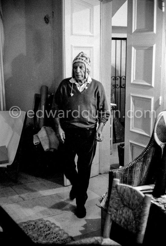 To strike a pose, Pablo Picasso tries on hats from his collection for his own amusement and that of his guests. Mas Notre-Dame-de-Vie, Mougins 1964. - Photo by Edward Quinn