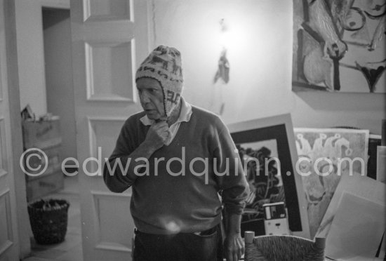 To strike a pose, Pablo Picasso tries on hats from his collection for his own amusement and that of his guests. Mas Notre-Dame-de-Vie, Mougins 1964. - Photo by Edward Quinn
