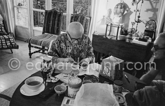 Pablo Picasso  engraving his signature on a small lucky dollar coin. Visitors usually brought some object or present that they hoped would interest or intrigue Pablo Picasso, and they were seldom disappointed. Mas Notre-Dame-de-Vie, Mougins 1967. - Photo by Edward Quinn