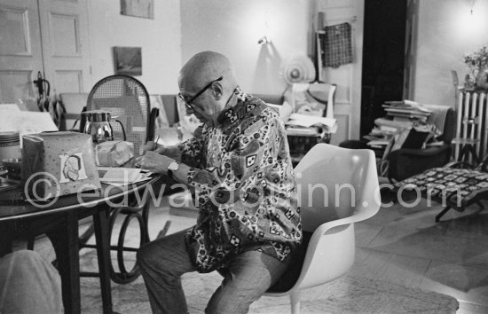 Pablo Picasso  engraving his signature on a small lucky dollar coin. Visitors usually brought some object or present that they hoped would interest or intrigue Pablo Picasso, and they were seldom disappointed. Mas Notre-Dame-de-Vie, Mougins 1967. - Photo by Edward Quinn