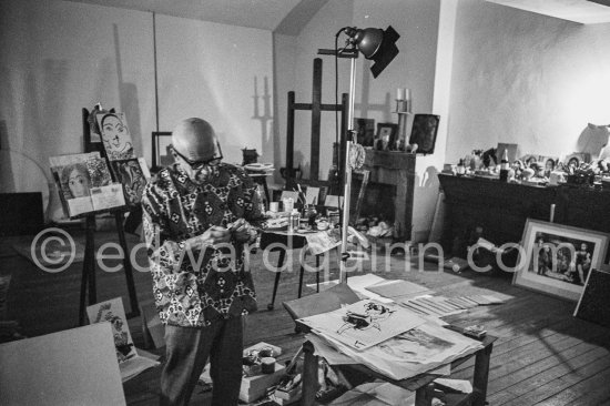 Pablo Picasso checks a small lucky dollar coin on which he engraved his signatureat a visitor’s request. Visitors usually brought some object or present that they hoped would interest or intrigue Pablo Picasso, and they were seldom disappointed. Mas Notre-Dame-de-Vie, Mougins 1967. - Photo by Edward Quinn