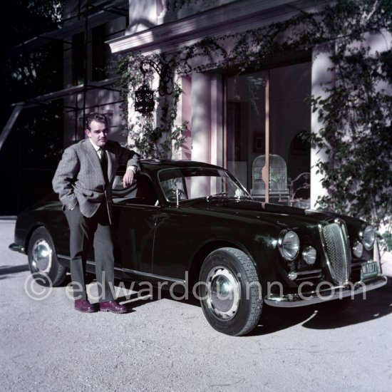 Car enthusiast Prince Rainier of Monaco at his Villa Iberia. He competed under the pseudonym of Louis Carladès at the Tour de France de l\'automobile and crashed into a tree. Saint-Jean-Cap-Ferrat 1954. Car: Lancia Aurelia B20 Gran Turismo 2500 - Photo by Edward Quinn