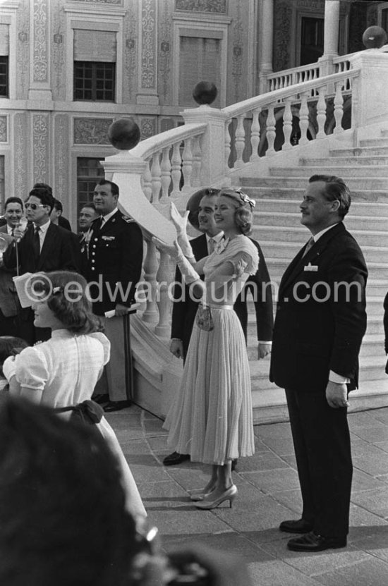 Prince Rainier and Princess Grace meeting Monegasque people in the courtyard of the Royal Palace, Monaco 1956 for the official reception of the wedding presents. Grace Kelly wore a pale blue chiffon day dress by the California designer James Galanos. She accessorized z^the dress with a small headpiece of matching blue ribbon, white gloves and the same Morabito needlepoint bag she had carried to the Academy Award of 1955. - Photo by Edward Quinn