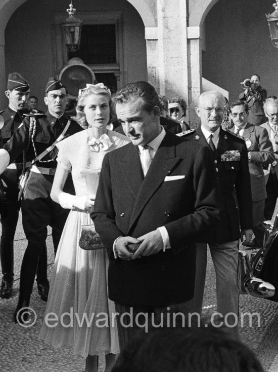 Prince Rainier and Princess Grace meeting Monegasque people in the courtyard of the Royal Palace. Monaco 1956 for the official reception of the wedding presents. Grace Kelly wore a pale blue chiffon day dress by the California designer James Galanos. She accessorized z^the dress with a small headpiece of matching blue ribbon, white gloves and the same Morabito needlepoint bag she had carried to the Academy Award of 1955. - Photo by Edward Quinn