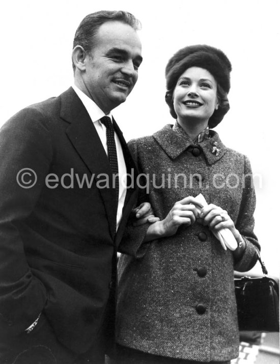 Rainier, Prince of Monaco and Princess Grace. On board the liner "Constitution", arriving from the U.S. after a six week trip to the United States. Monaco 1956. (Grace Kelly). She wears a tailored suit with a gently flared jacket and the Cartier brooch in the shape of a poodle that was one of her favorite pieces of jewelry. - Photo by Edward Quinn