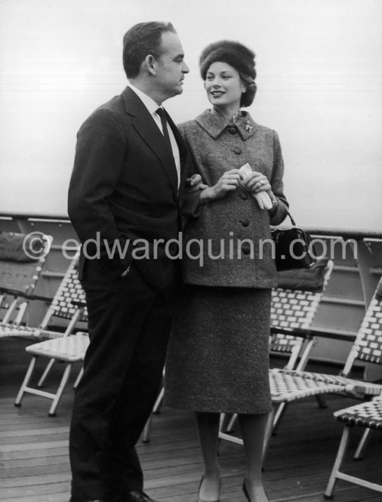 Rainier, Prince of Monaco and Princess Grace. On board the liner "Constitution", arriving from the U.S. after a six week trip to the United States. Monaco 1956. (Grace Kelly) She wears a tailored suit with a gel^ntly flared jacket and the Cartier brooch in the shapeof a poodle that was one of her favorite pieces of jewelry. - Photo by Edward Quinn