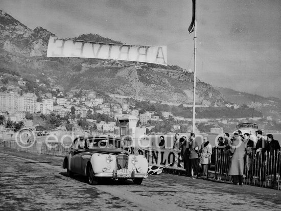 N° 63 Sosa / Correia Lobo on Jaguar Mk VII taking part in the regularity speed test on the circuit of the Monaco Grand Prix. Rallye Monte Carlo 1953. To prevent the competitors from taking the timekeepers by surprise and passing without being spotted the organisers decided to paint the front wings of the cars white with washable paint. This enabled the officials to identify them a long way off even if their rally plates were not easily visible because of dirt or their position on the car. (Louche p. 118) - Photo by Edward Quinn