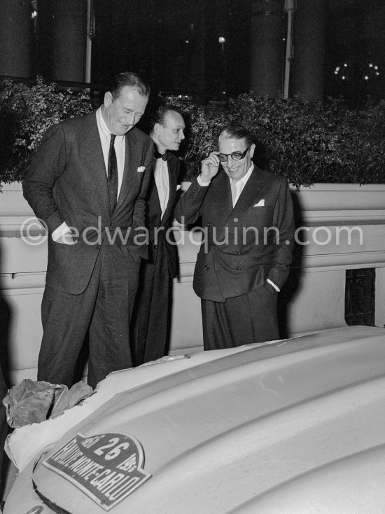 John Wayne and Aristotle Onassis. In good humour they study damaged car N°26 of Fabregas / Bassadonna Mercedes-Benz 300 SL Coupé of the Monte Carlo Rally. Monaco 1956 - Photo by Edward Quinn