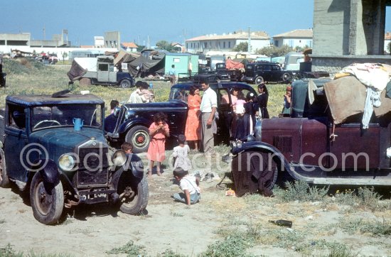 Gypsies on the occasion of the yearly pilgrimage and festival of the Gypsies in honor of Saint Sara, Saintes-Maries-de-la-Mer in 1953. Not identified cars. - Photo by Edward Quinn