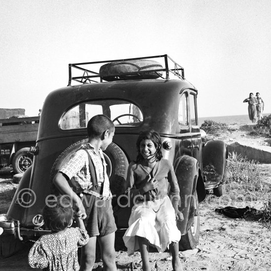 Gypsies on the occasion of the yearly pilgrimage and festival of the Gypsies in honor of Saint Sara, Saintes-Maries-de-la-Mer in 1953. Not identified car. - Photo by Edward Quinn