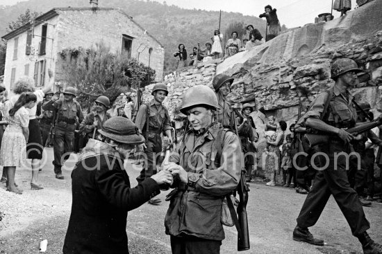 Frank Sinatra on the set of the film "Kings Go Forth" in the village of Tourette-sur-Loup, 1957. Sinatra needed an old lady to partner him in this scene. The villager Marie Isnard, who had never been to the cinema in her life, learned her lines and got through the dialogue very successfully. Sinatra\'s lines were: "Vive General de Gaulle, Vive les Folies-Bergère", about the only French he knew. - Photo by Edward Quinn